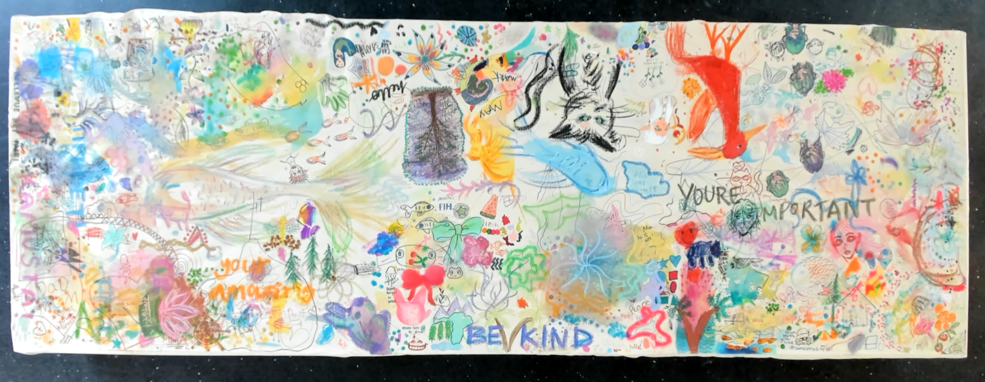 The Day 1 collaborative canvas filled with layered drawings, handprints, words, flowers, animals, and colourful marks.