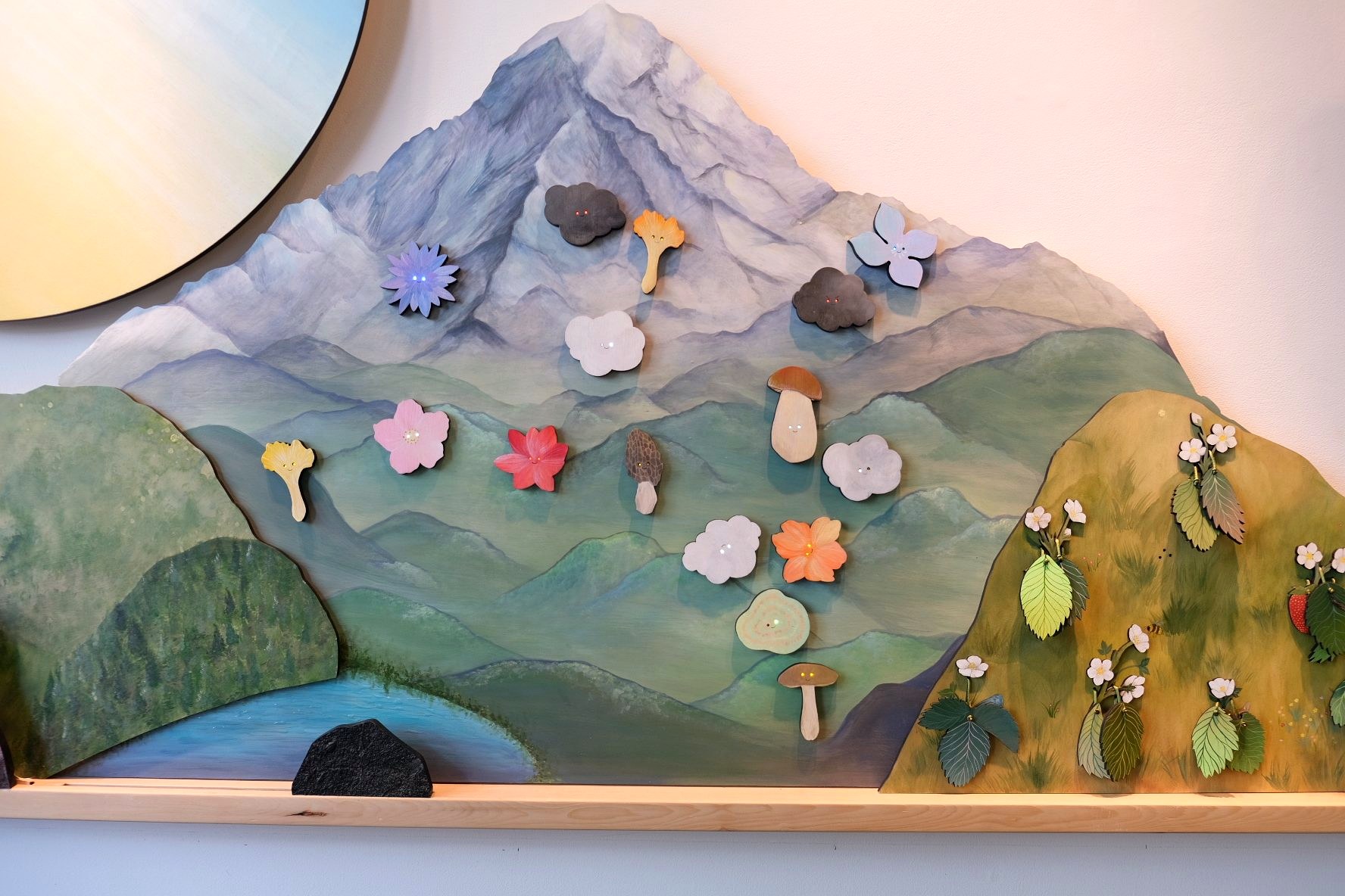 The magnetic mountain meadow filled with illuminated flowers, mushrooms, clouds, and other moveable elements.