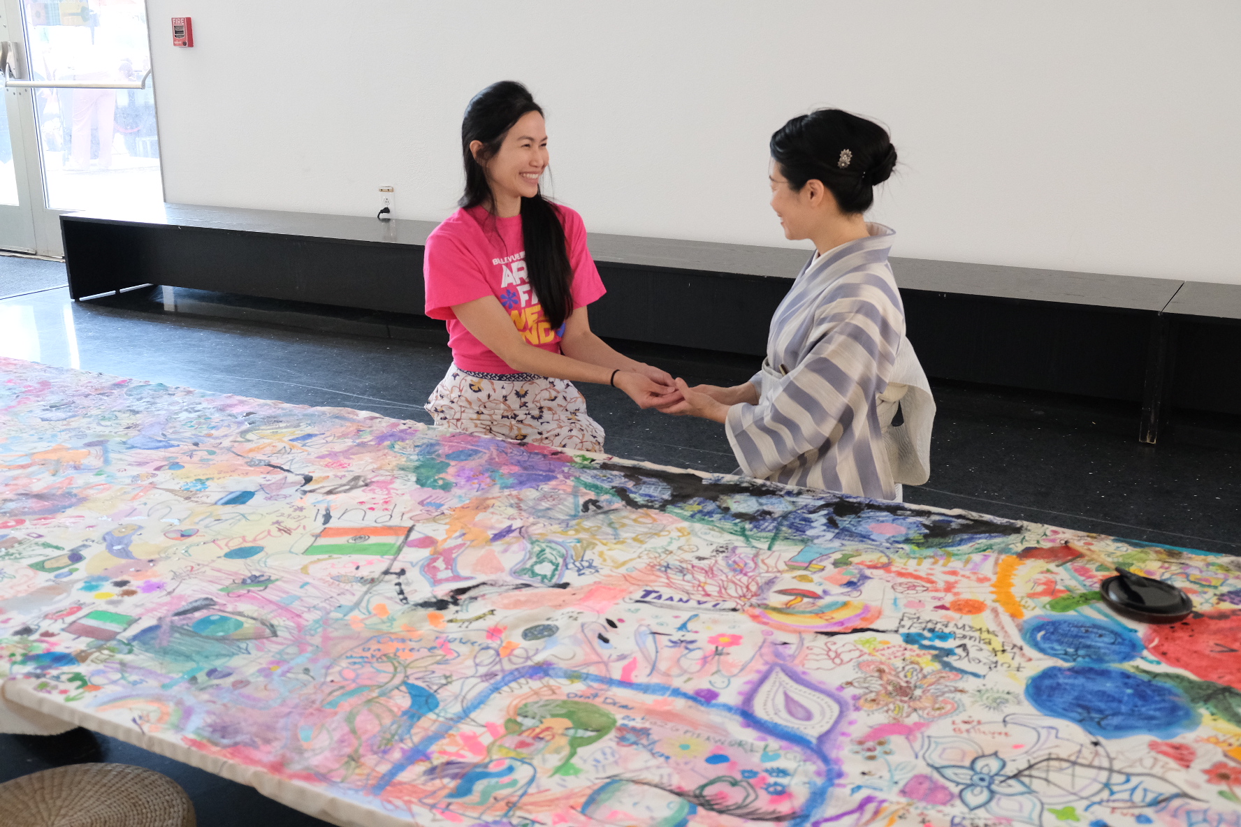 Rong Choy and Shizu Usami share a moment beside the completed collaborative canvas.