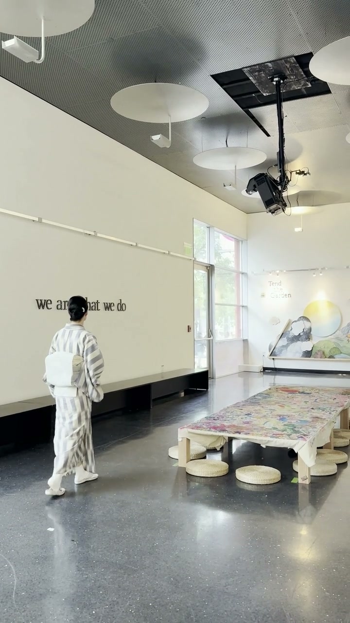 Shizu Usami walks into the gallery toward the completed collaborative canvas.